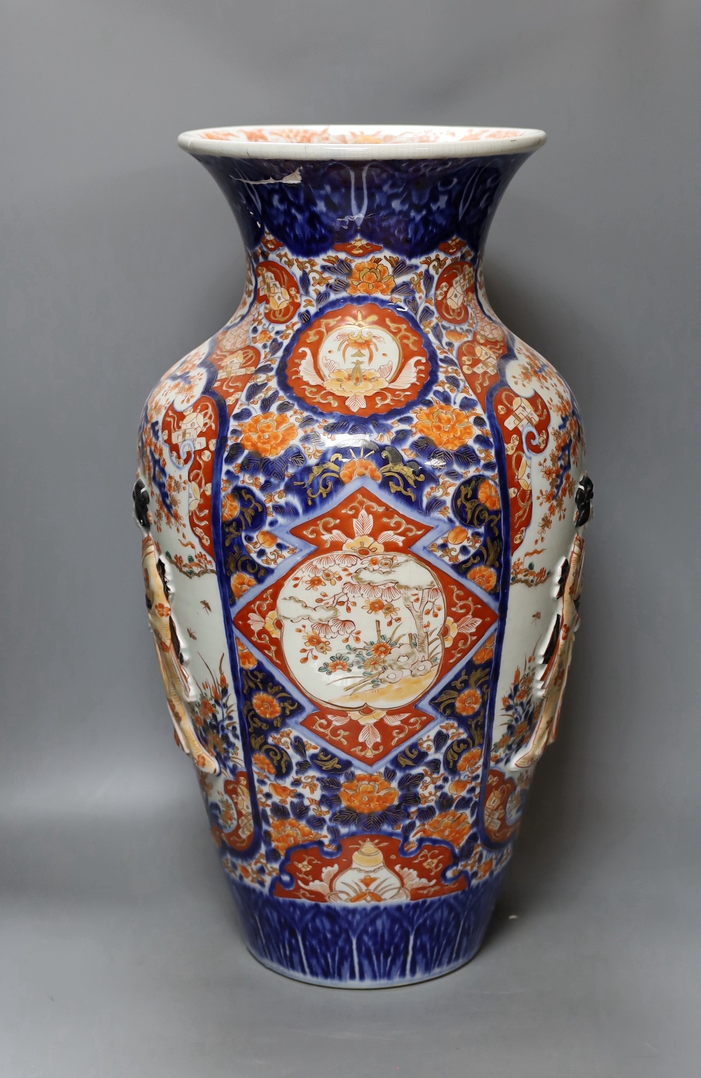 An unusual large Japanese Imari vase, Meiji period relief moulded with figures, 57cm tall, repairs